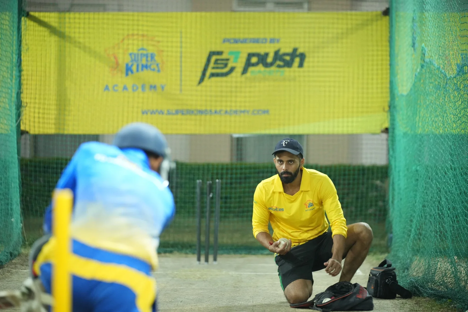 Coach guiding a young batsman at Super Kings Academy nets